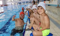 Ortopedik engelli antrenör çocuklara yüzme öğretiyor